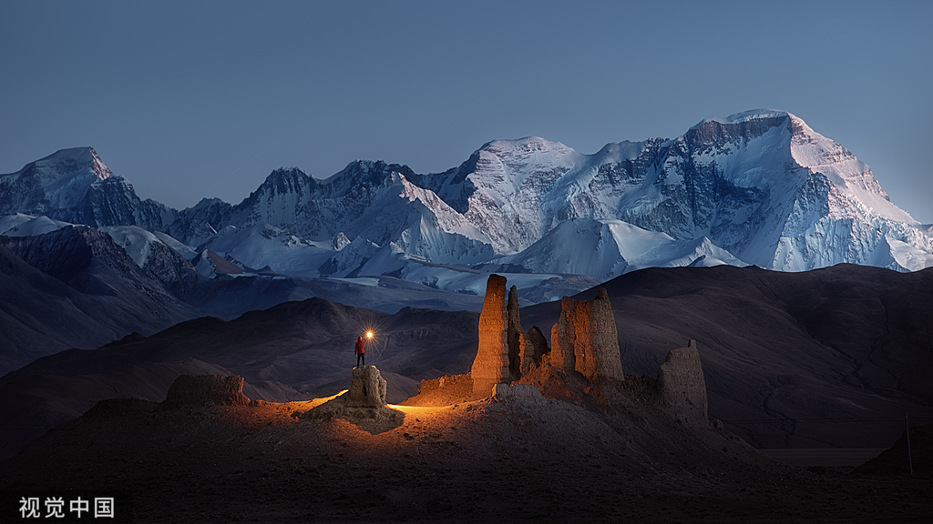 Highland dusk — ruins beneath snow peaks